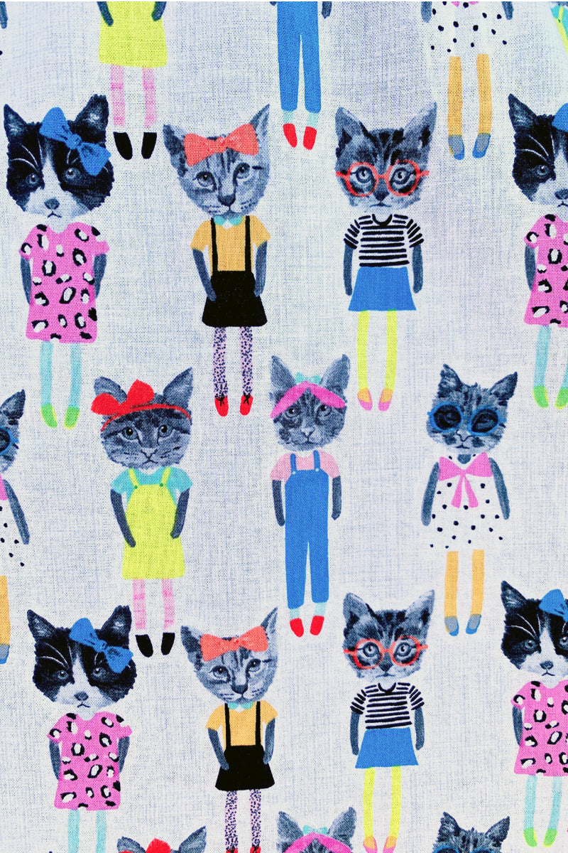 a close up of the fabric showing cats dressed up in fashionable clothes