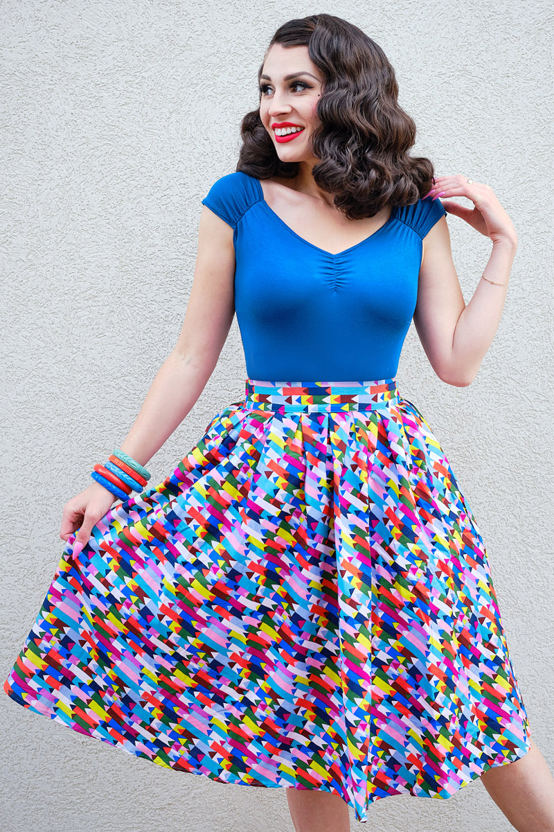 model standing in front of a wall wearing our Isabel top in peacock blue