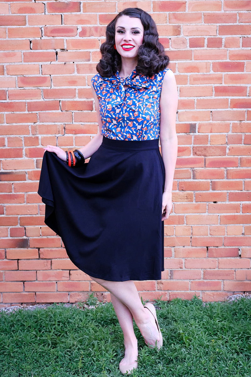 full length of model standing in front of a brick wall wearing our mushroom bow top