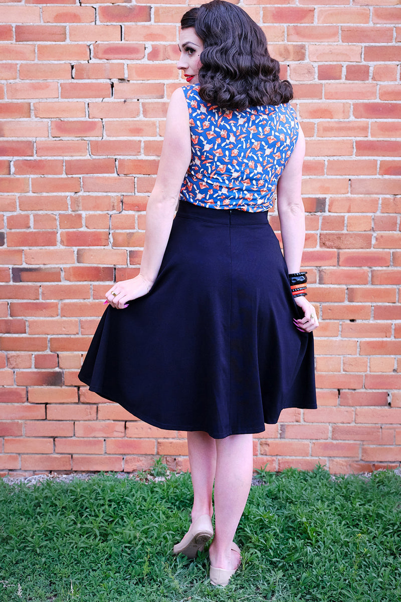 back view of model standing in front of a brick wall wearing our mushroom bow top