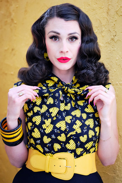 close up of model standing in front of a yellow wall wearing our honey hives bow top