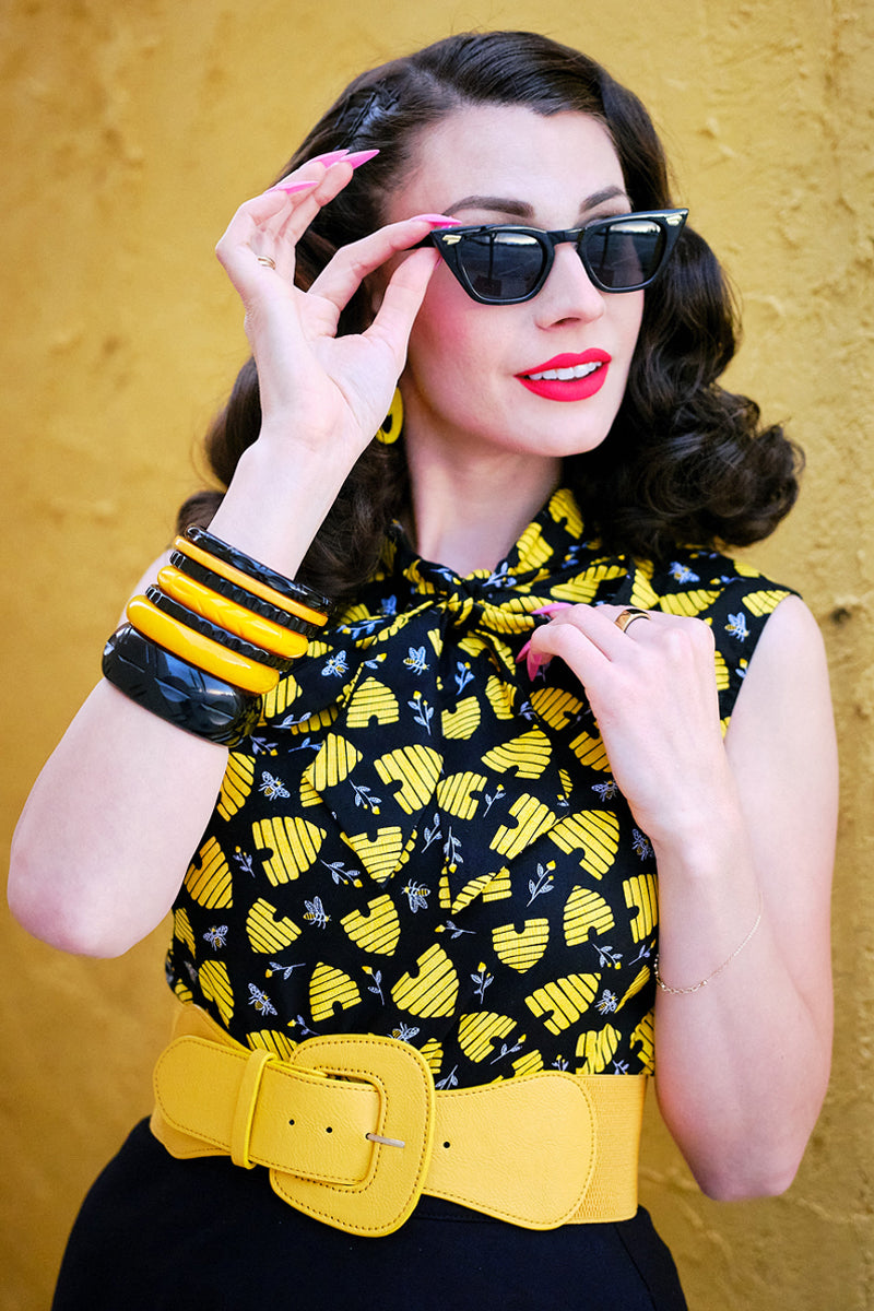 close up of model standing in front of a yellow wall wearing our honey hives bow top