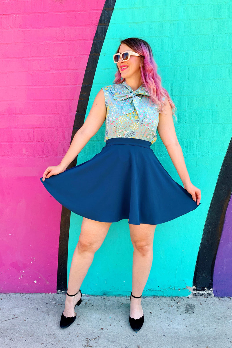 a model standing in front of coloful wall wearing the ocean blue skater skirt