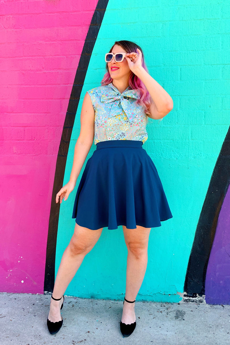 a model standing in front of coloful wall wearing the ocean blue skater skirt