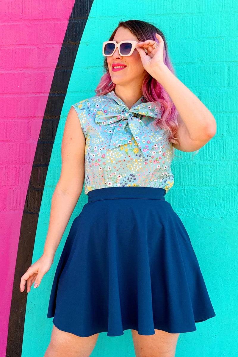 a model standing in front of coloful wall wearing the ocean blue skater skirt