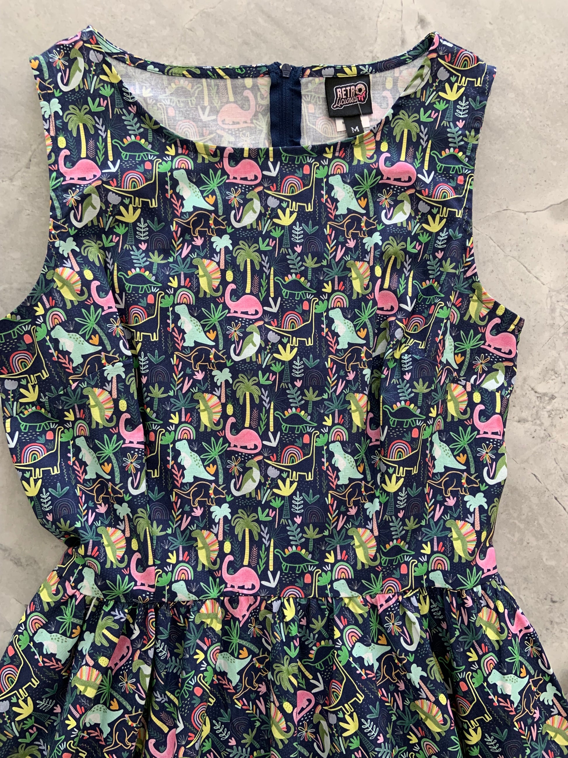a flat lay of dinos and rainbows vintage dress