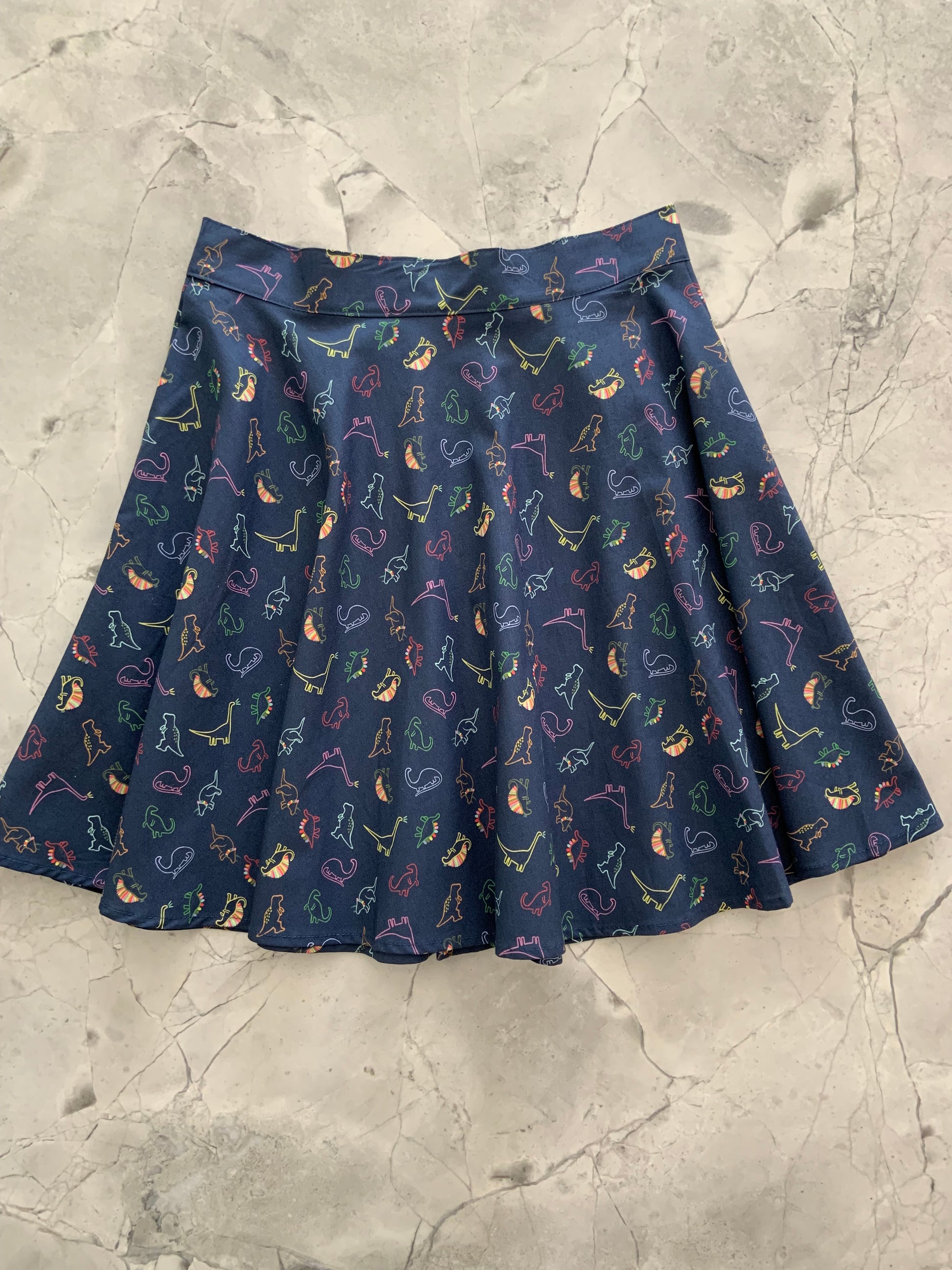 a flat lay of neon dinos skater skirt