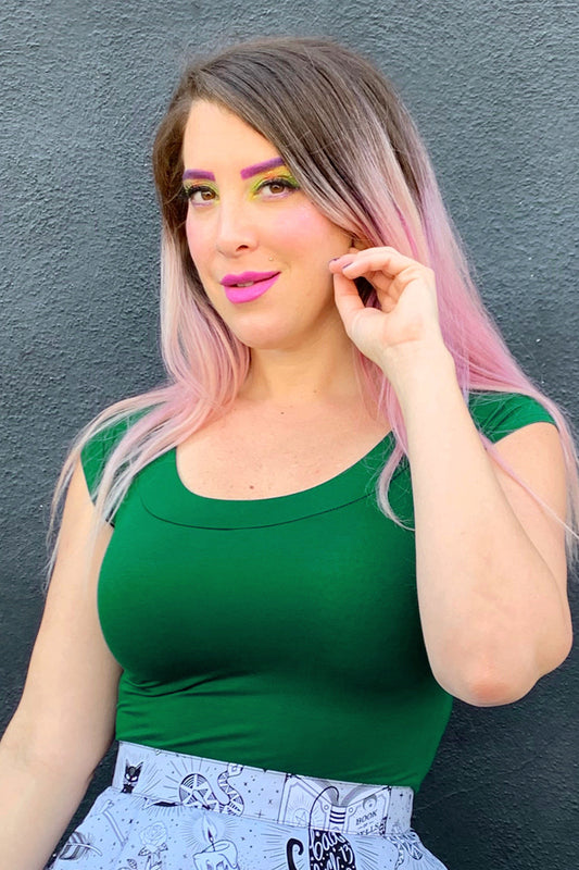 a close up of a model wearing retro boat neck top in kelly green