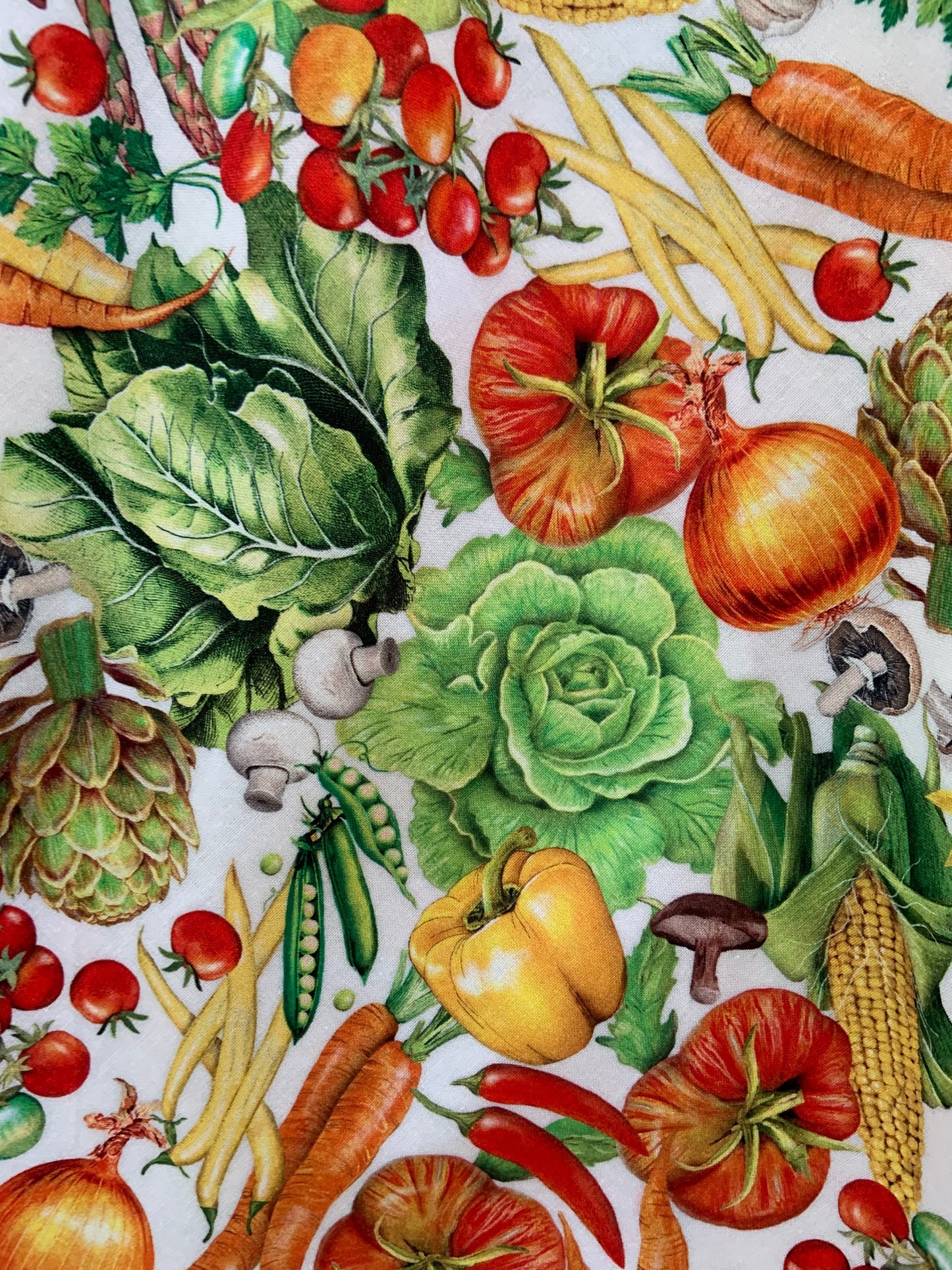 a close up of the fabric showing the tossed veggies on a white background