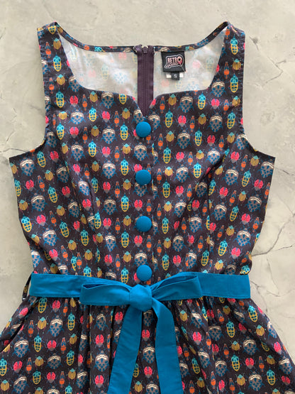 a close up of bodice of insects ida dress showing blue buttons and sash