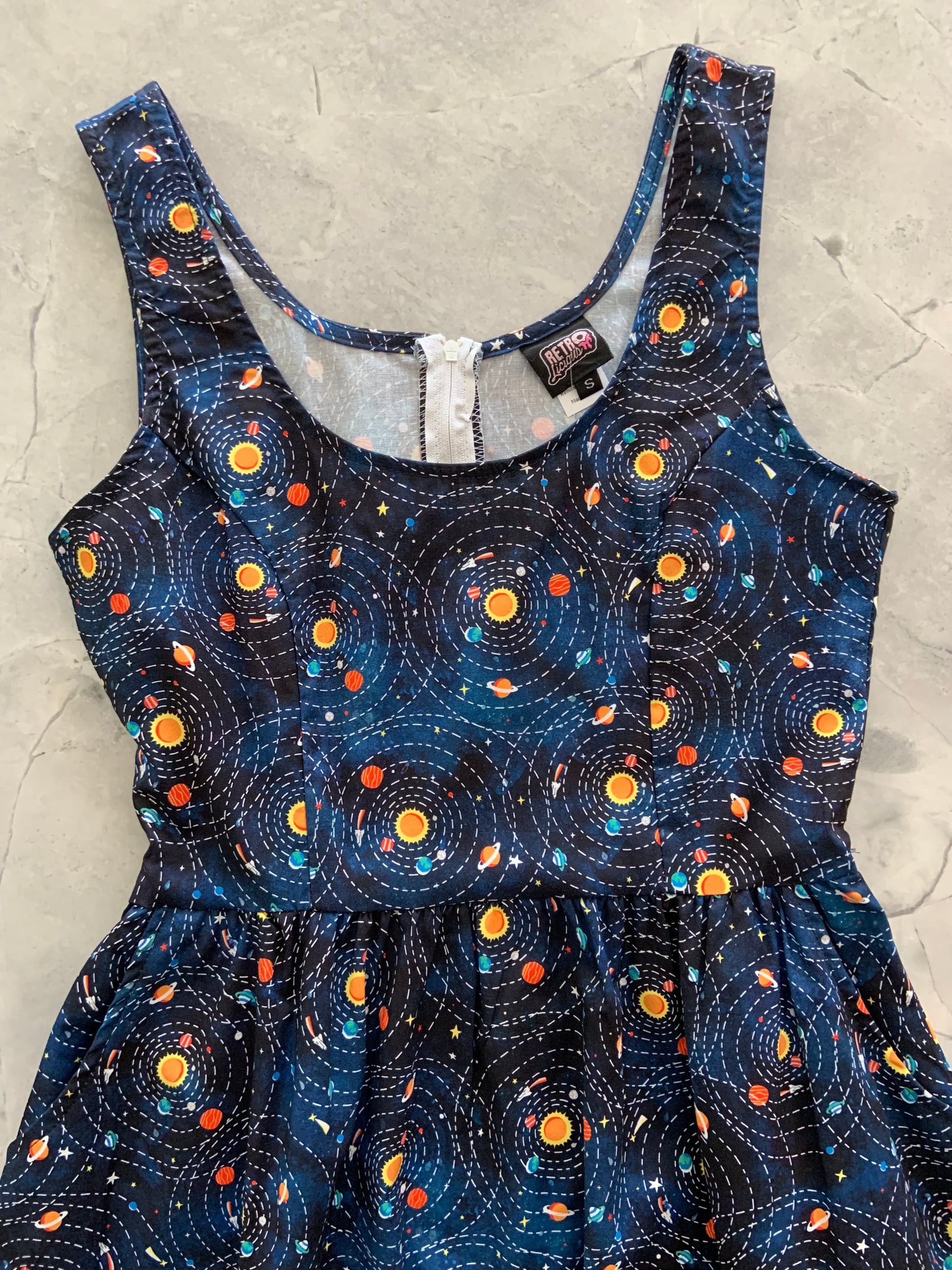 a close up of the flat lay of the front of the planetary alignment fit and flare dress
