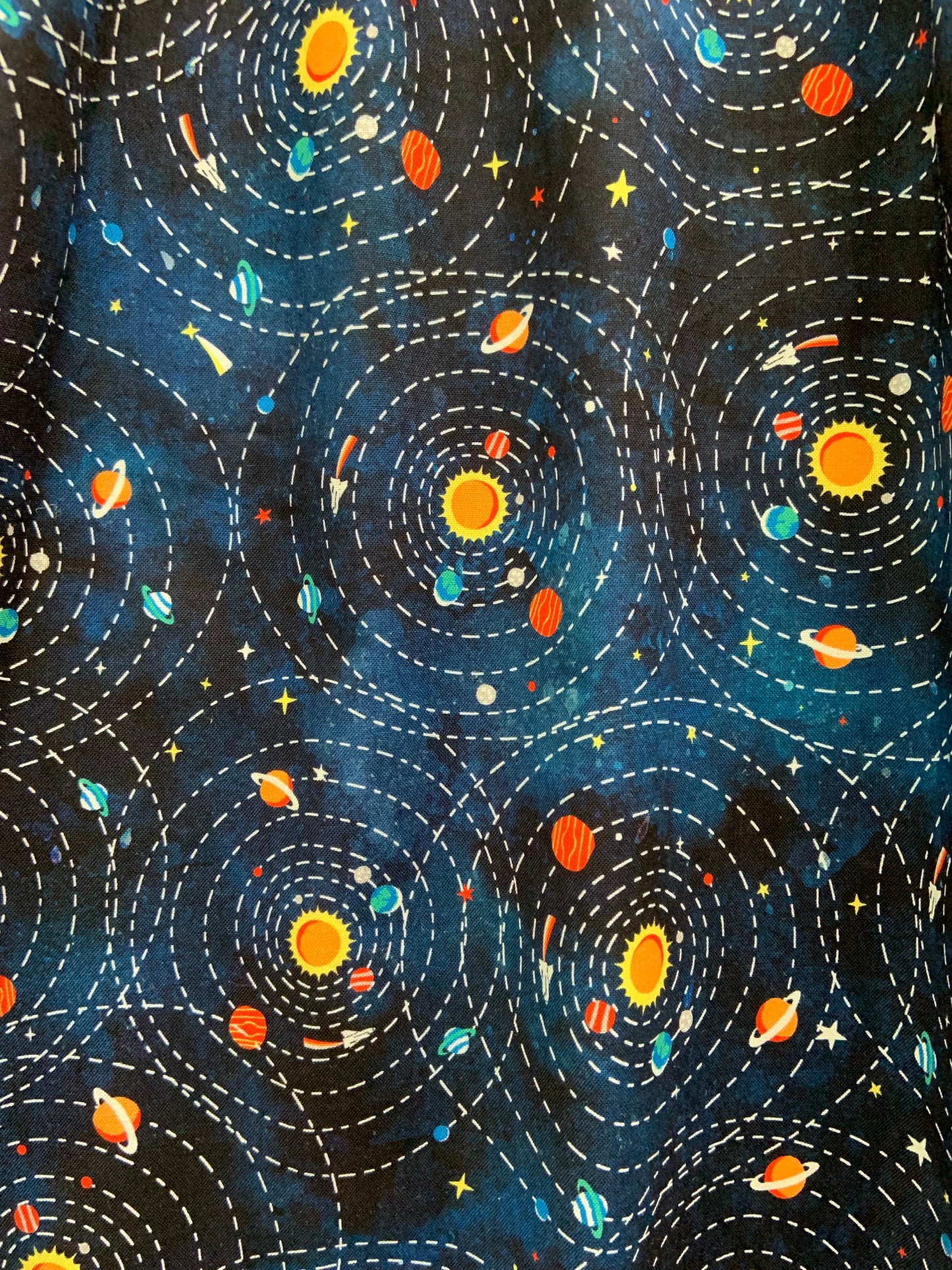 a close up of the fabric of the planetary alignment fit and flare dress showing the planets around the sun and the orbits