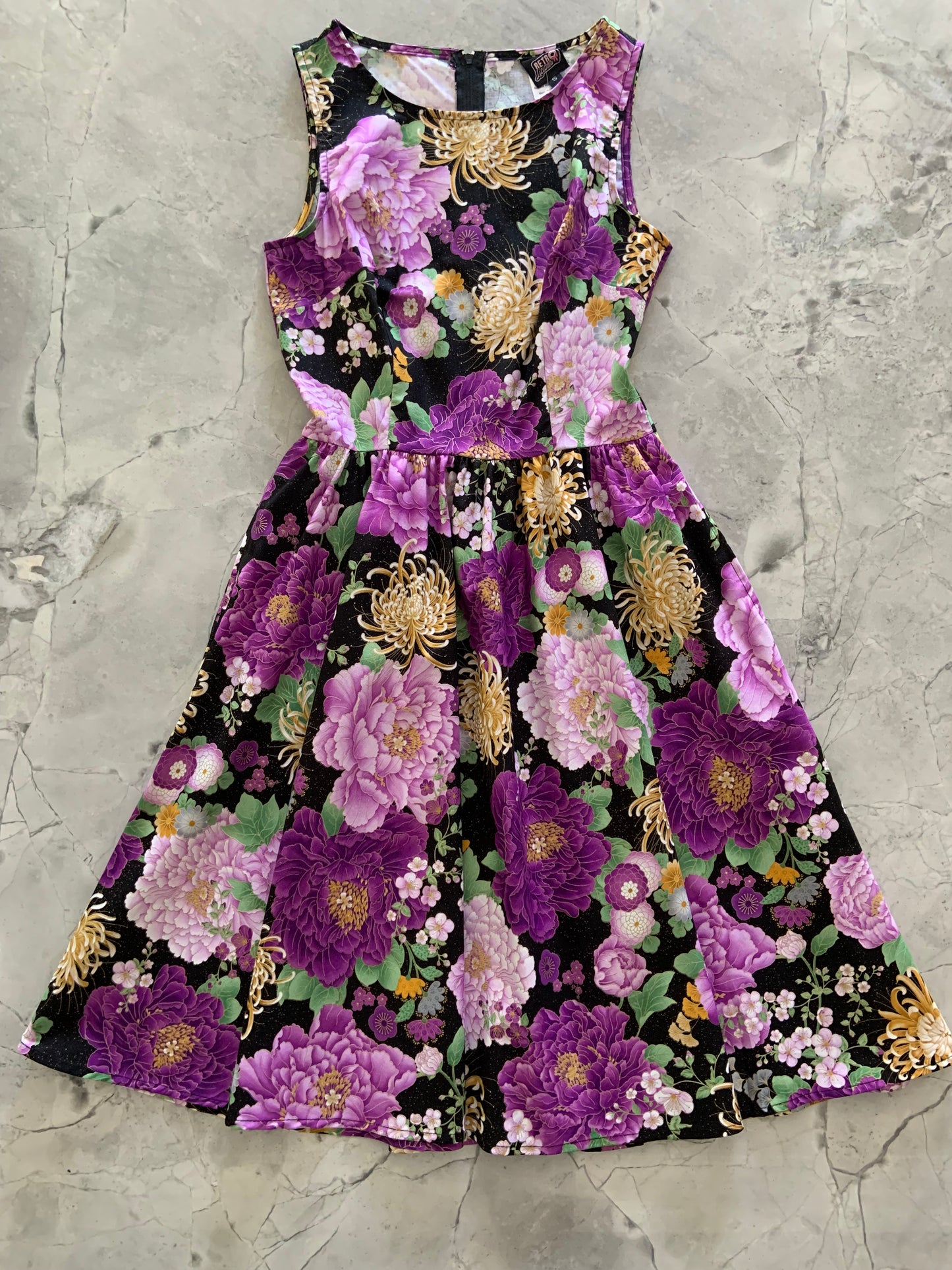 a flat lay of the front of the purple metallic floral vintage dress