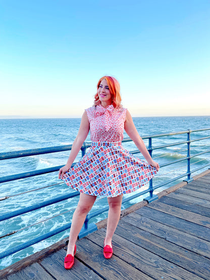 a model standing on boardwalk with the ocean in the background wearing sunny days skater skirt