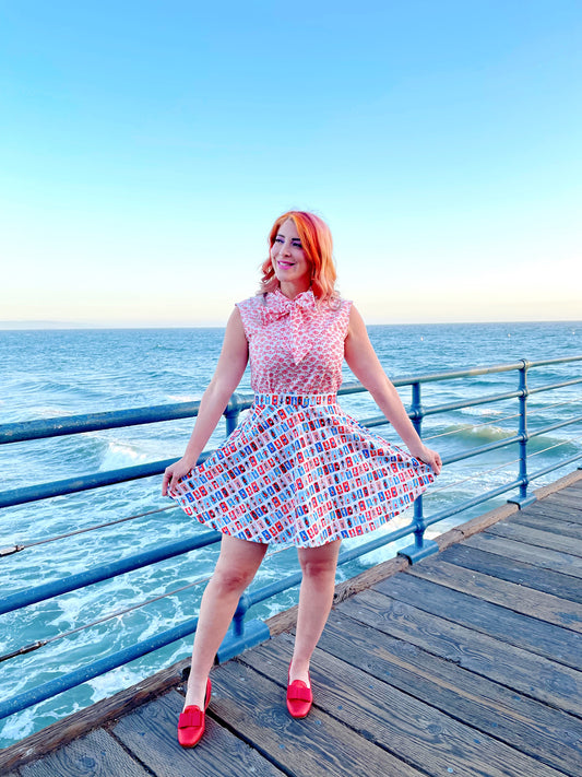 a model standing on boardwalk with the ocean in the background wearing sunny days skater skirt