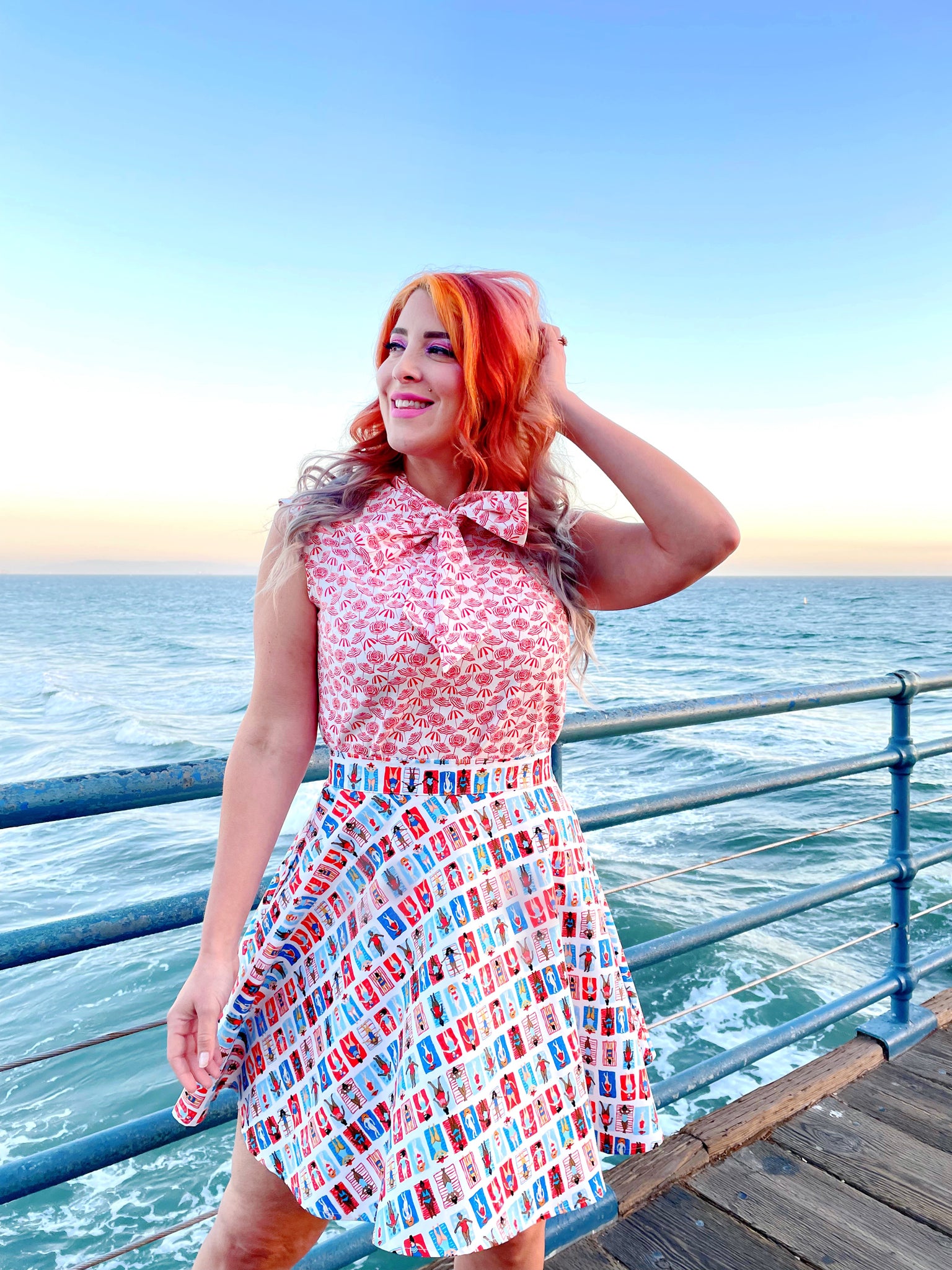 a close up of a model standing in front of the ocean wearing our umbrella bow top