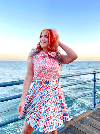 a close up of a model standing in front of the ocean wearing our umbrella bow top