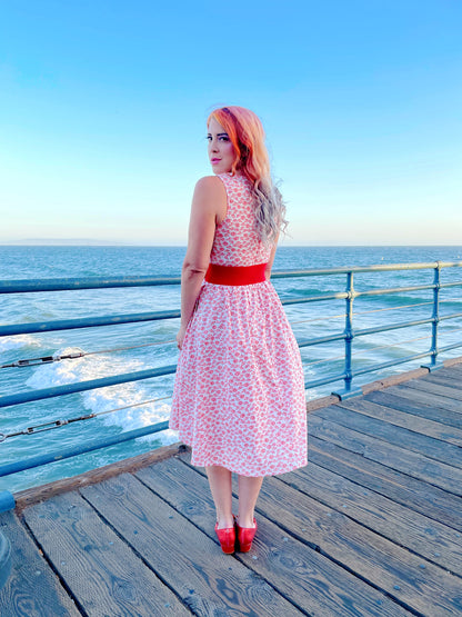 a back view of model standing on the boardwalk in front of the ocean wearing umbrella midi dress