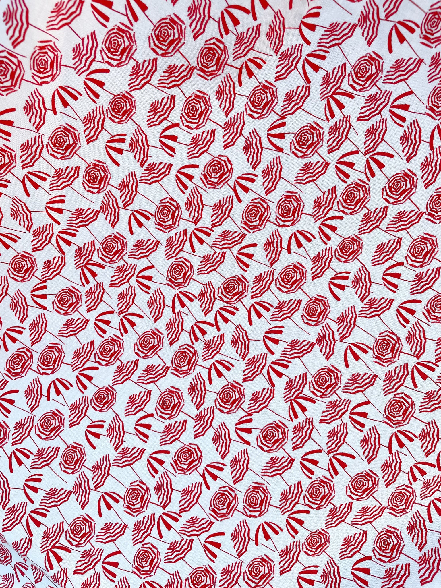 a close up of the fabric with red umbrellas on white background