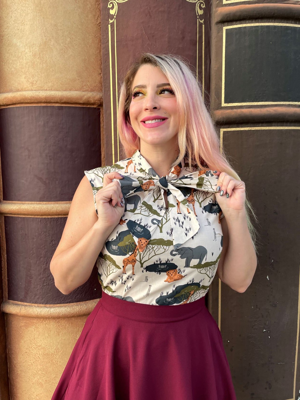 a close up of a model wearing the safari bow top and holding on to the ties of the bow
