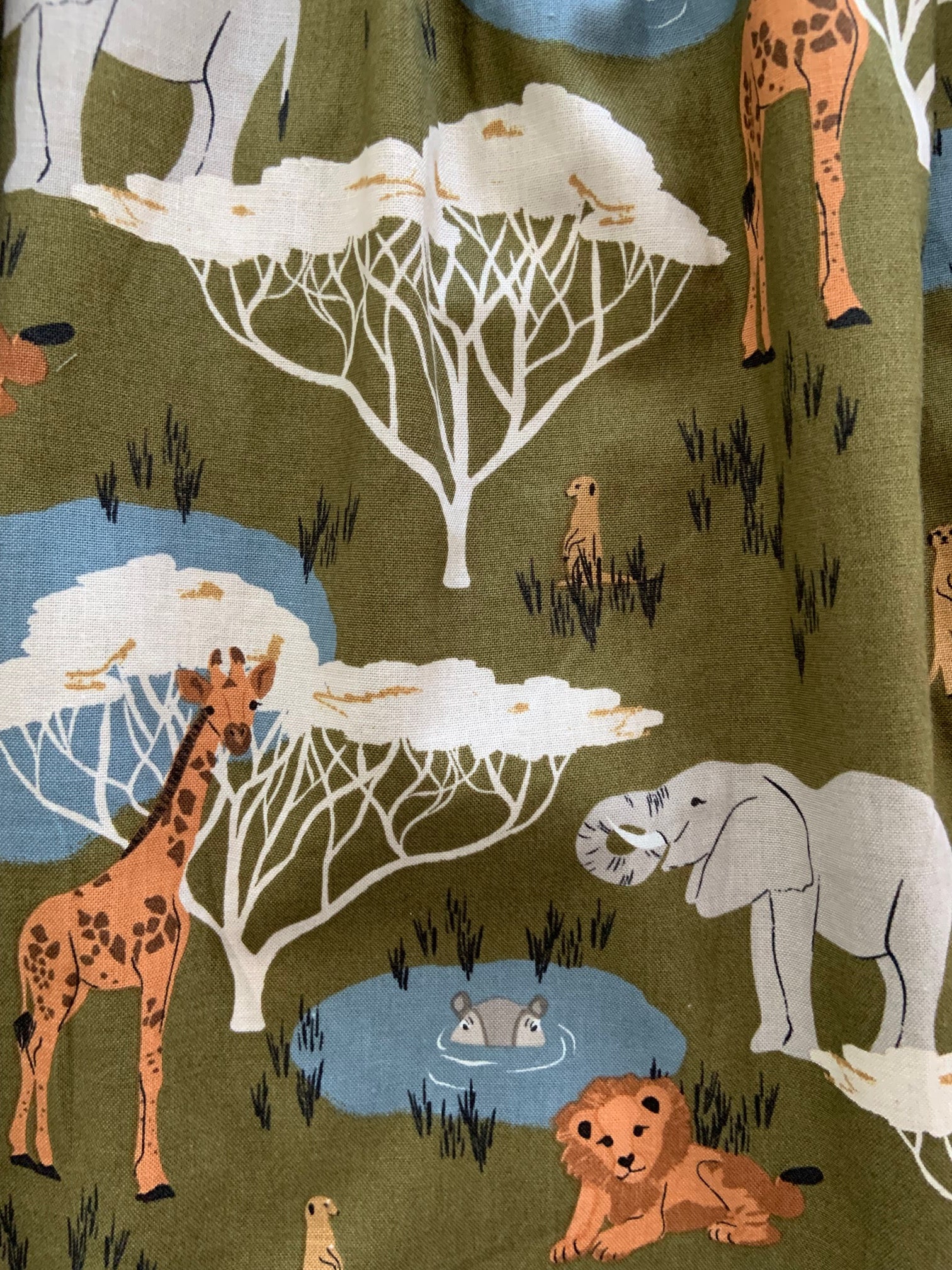 a close up of fabric of safari collared dress showing different safari animals
