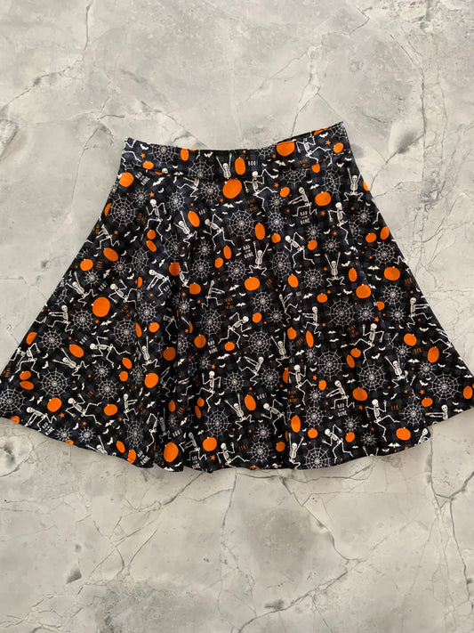 a flat lay of the front of the glow in the dark dancing bones skater skirt