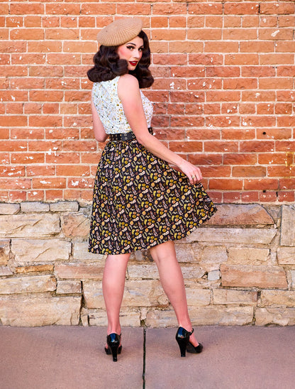 a photo of a model wearing a dress with upper half with snail print and skirt with a leaf print