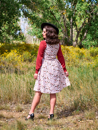 a back view model standing outdoors in front of trees wearing the butterfly vintage dress in cream