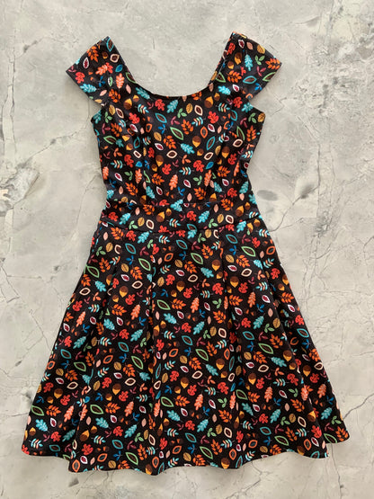 a flat lay of leaves and acorns margaret dress