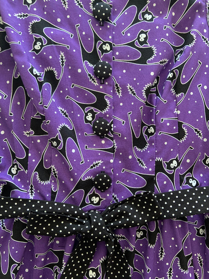 a close up of the front of bodice of scaredy cats ida dress showing polka dot buttons and sash