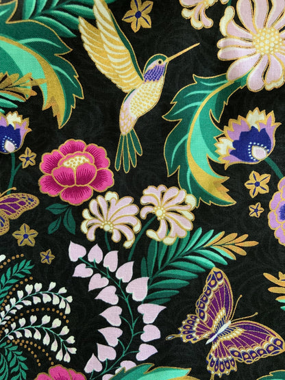 a close up of the fabric of the hummingbird vintage dress showing gold accents 