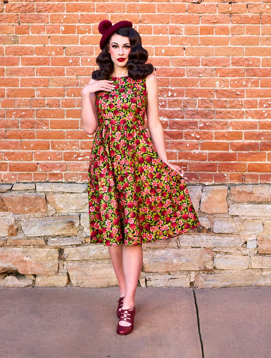 a full length image of a model standing in front of a brick wall wearing the Pomegranate Midi dress
