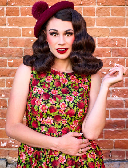 a close up image of a model standing in front of a brick wall wearing the Pomegranate Midi dress