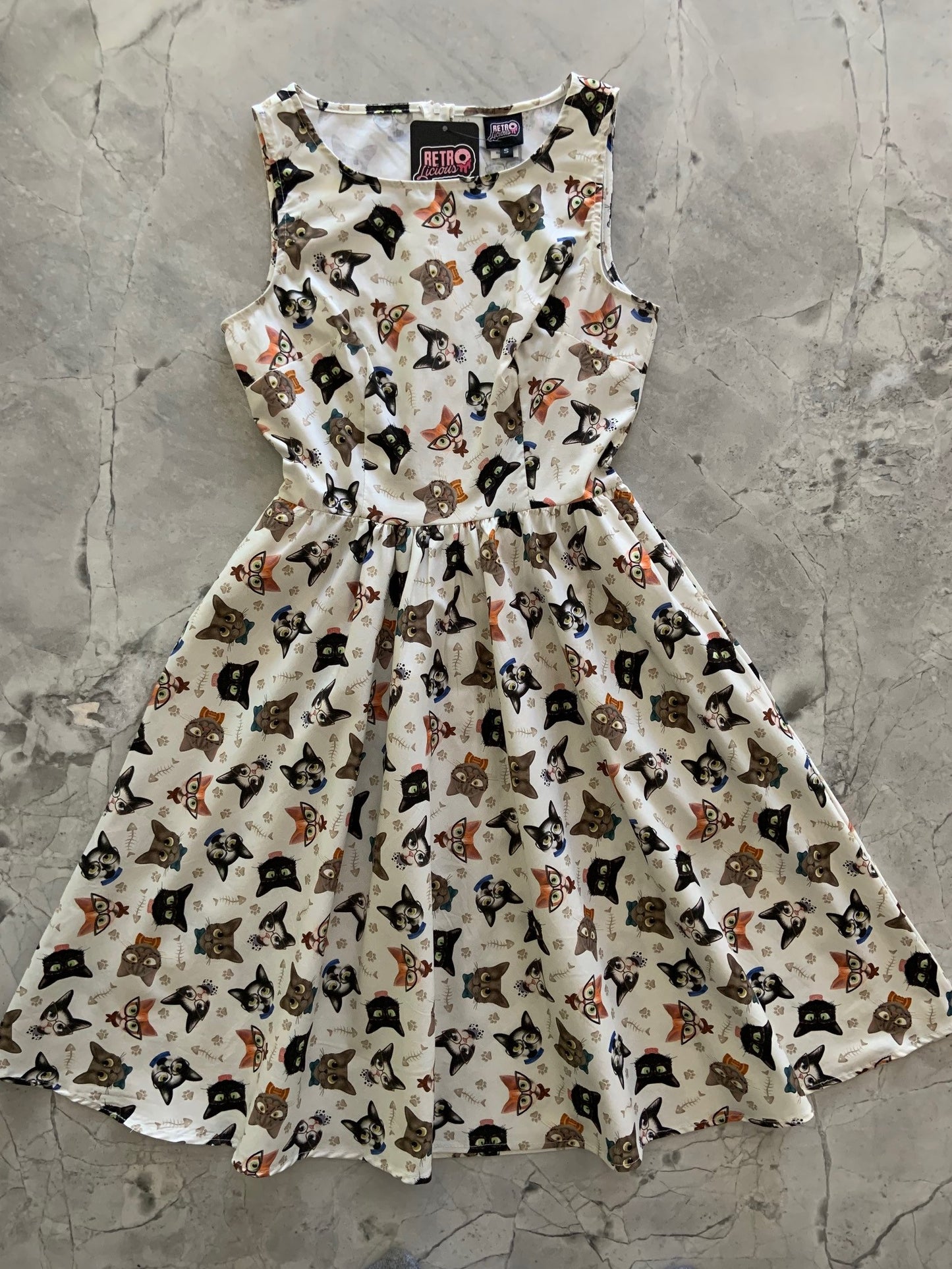 a flat lay of feline fabulous dress