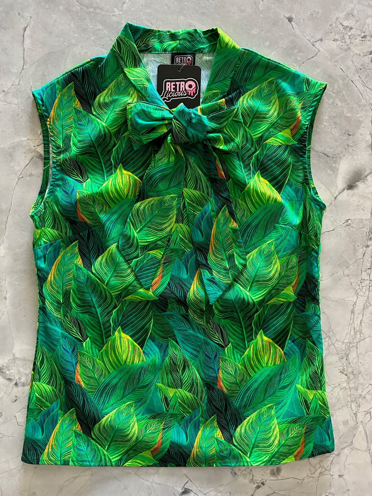 a flay lay of our bow tie blouse with leaves fabric