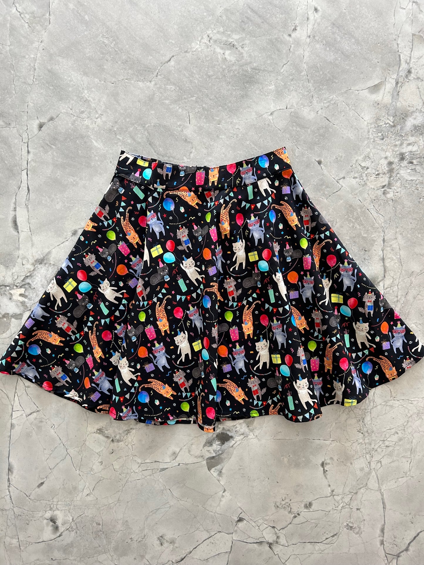 a flat lay of the front of the party cats skater skirt