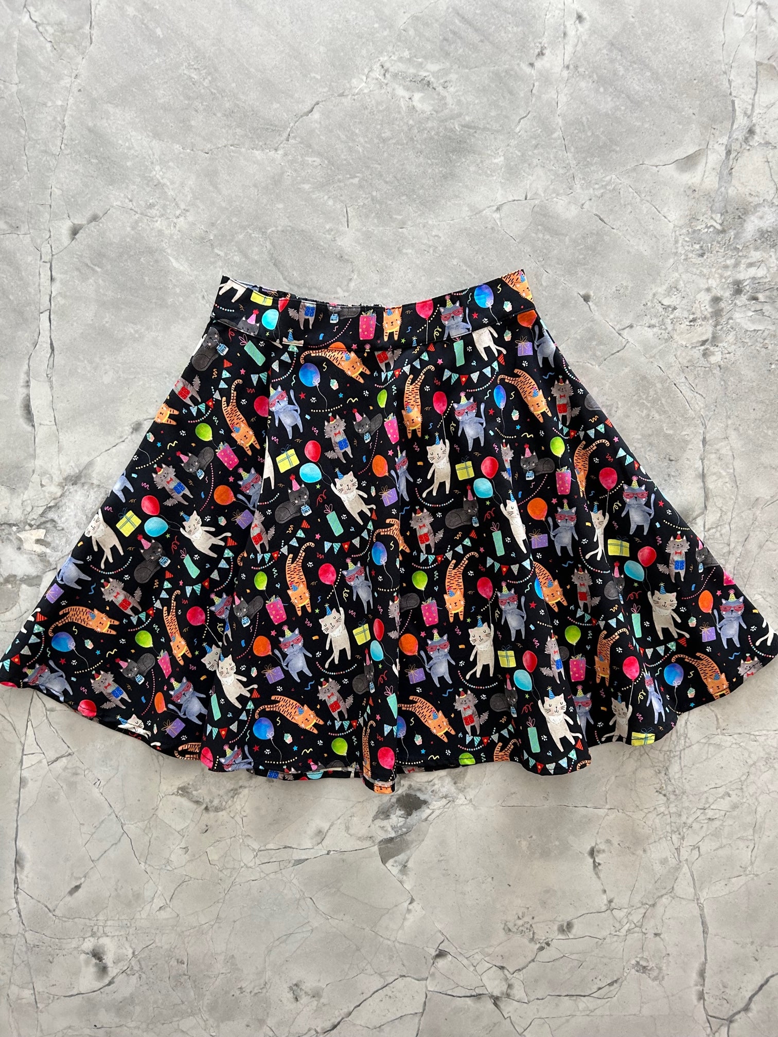 a flat lay of the front of the party cats skater skirt