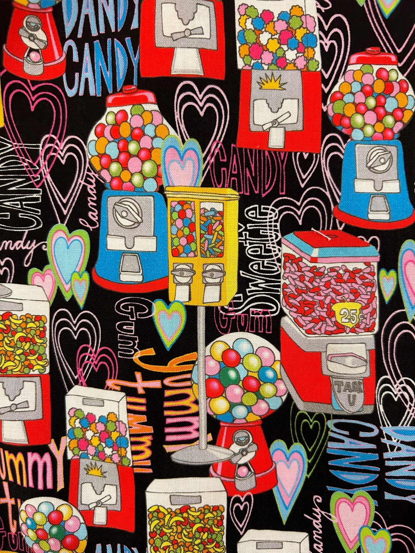 a close up of the fabric showing the gumball and candy machines on black background with hearts