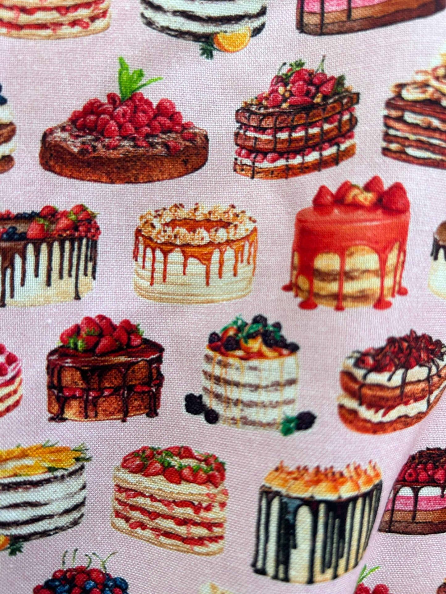 a close up of fabric showing cakes on pink background