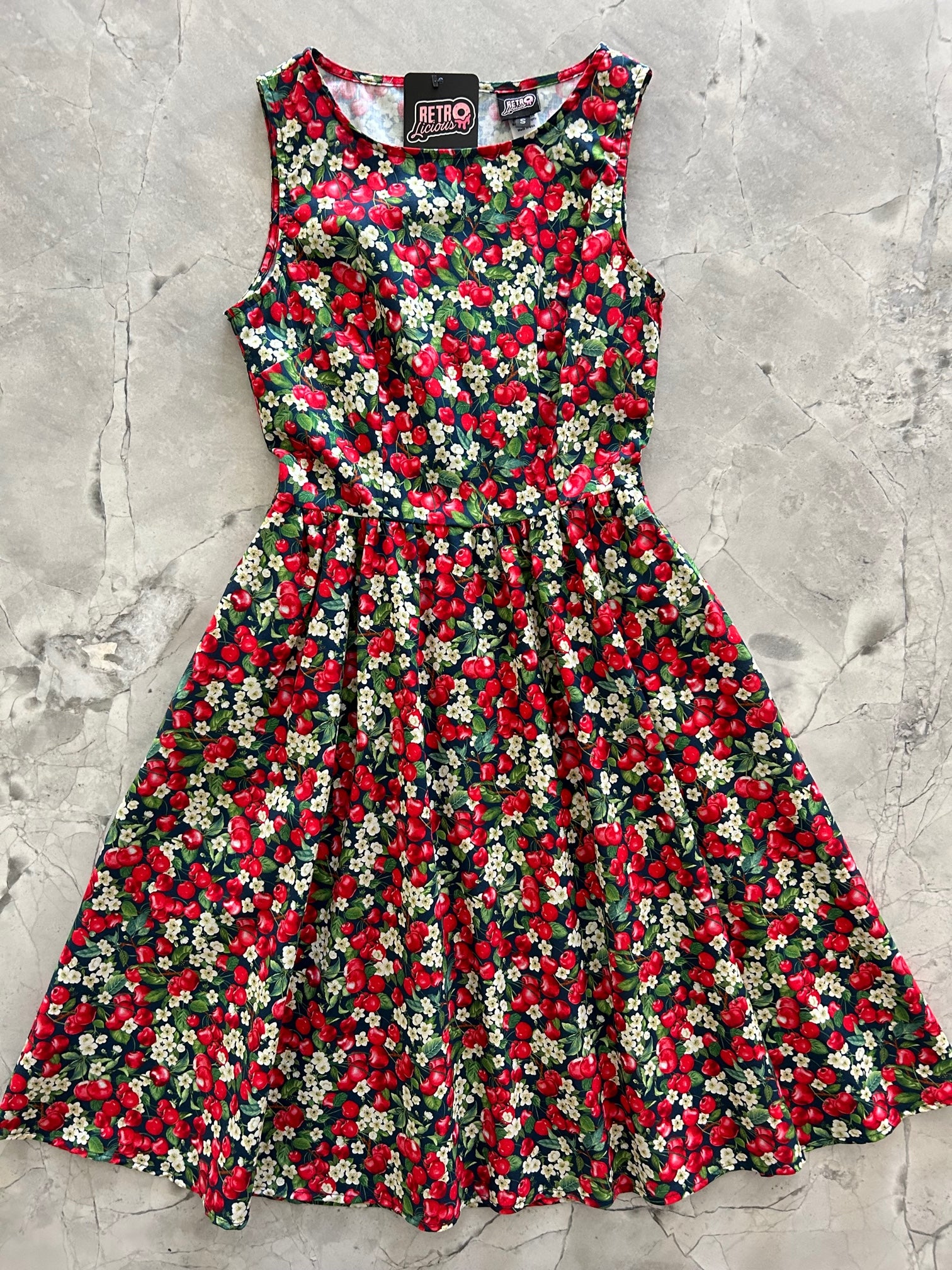 a flat lay of the front of the cherry good vintage dress