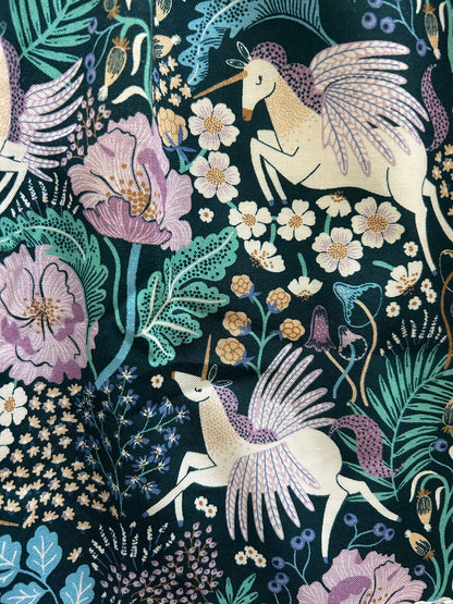a close up of the fabric of the garden of myths collared dress showibg mythical creatures in fields of flowers