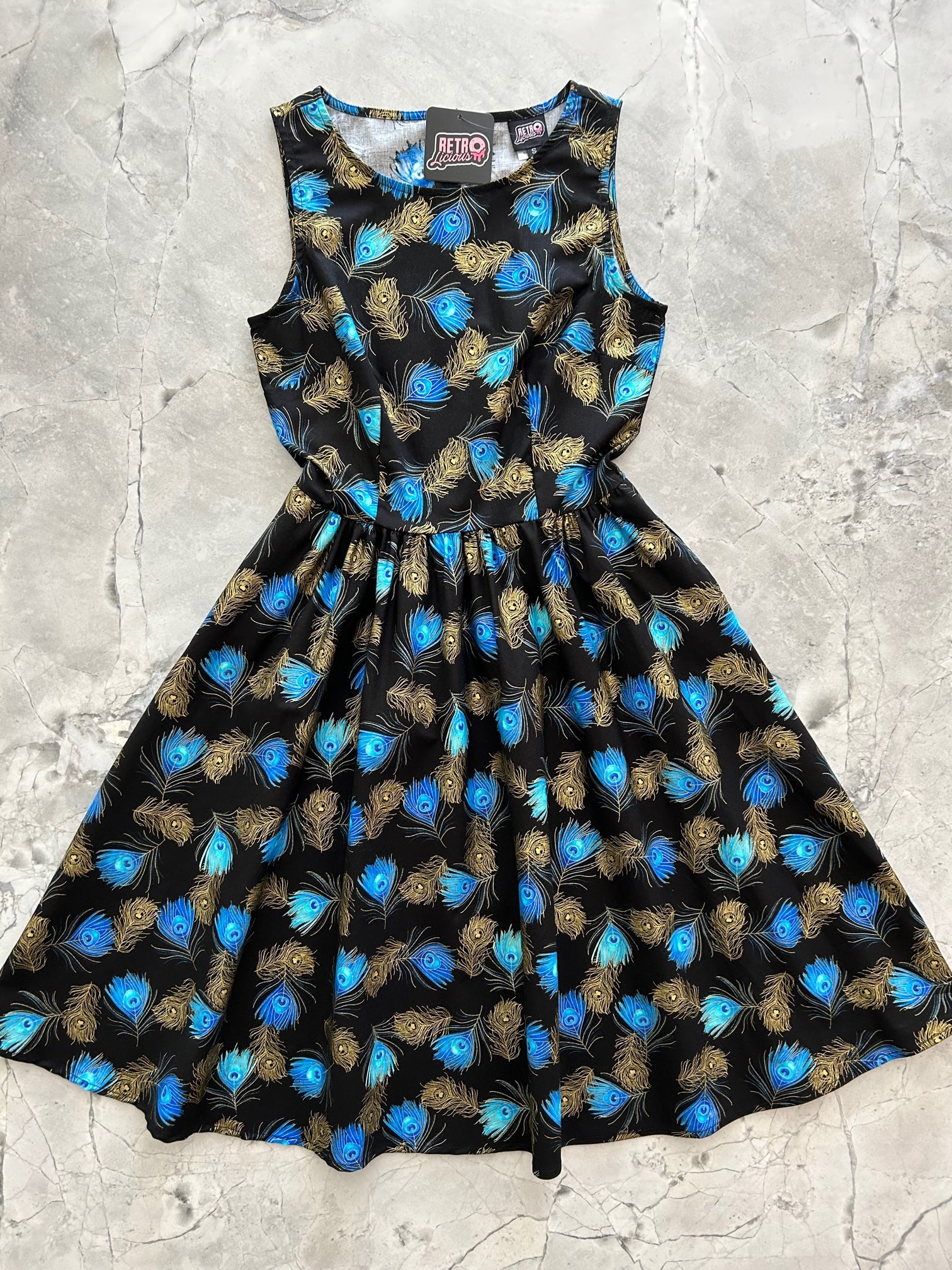a flat lay of the front of the peacock vintage dress
