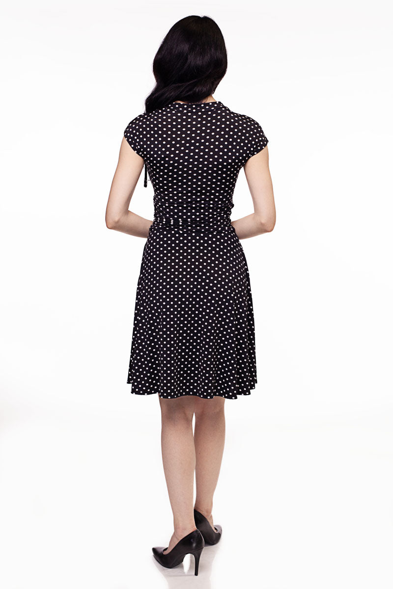 a full size image of the back of a model wearing the bridget bomshell dress in black and white polka dots