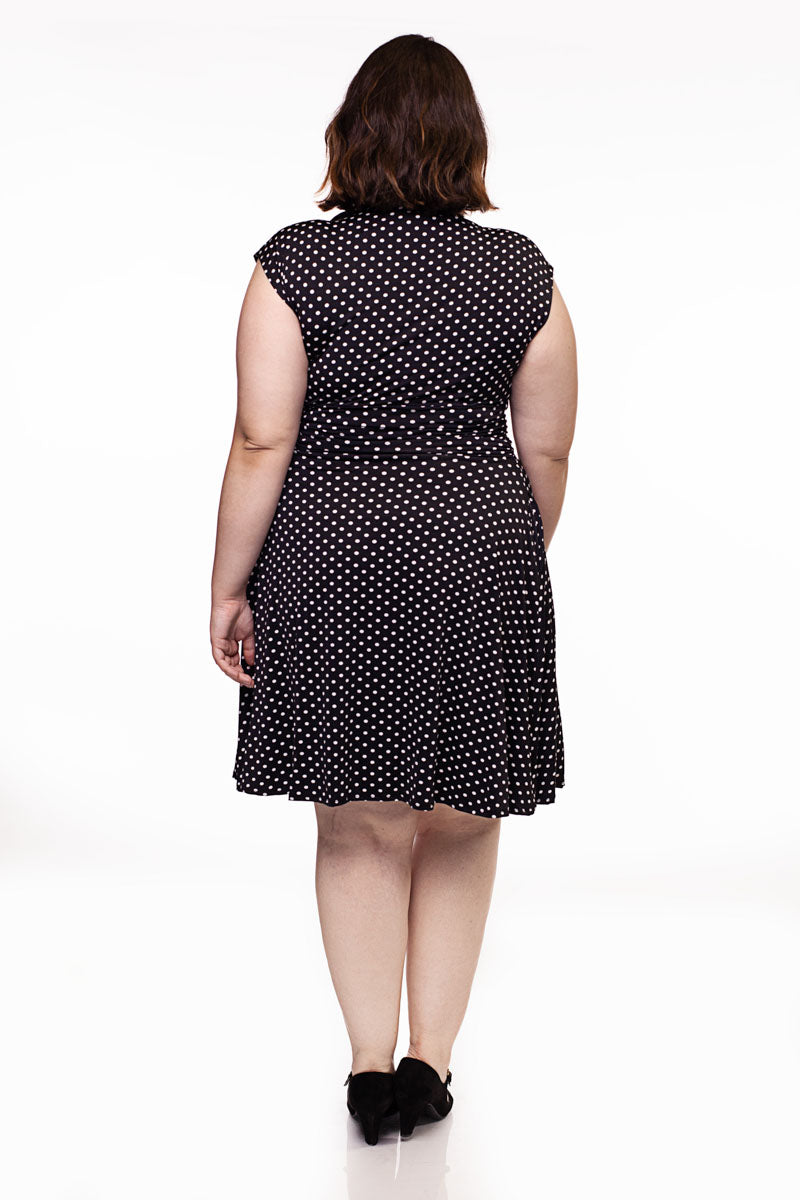 a full size image of the back of a plus size model wearing the bridget bomshell dress in black and white polka dots