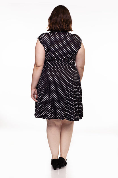 a full size image of the back of a plus size model wearing the bridget bomshell dress in black and white polka dots