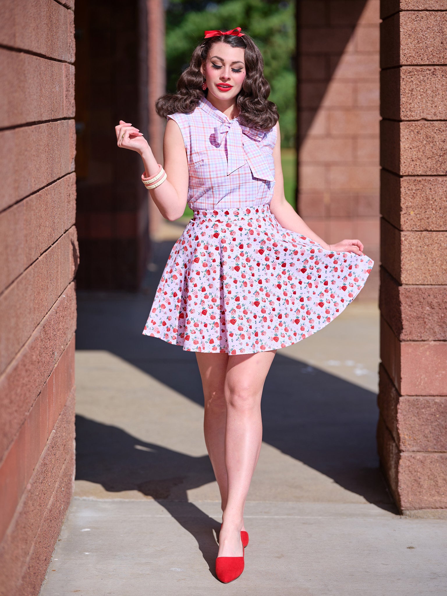 a model standing outside wearing strawberry skater skirt