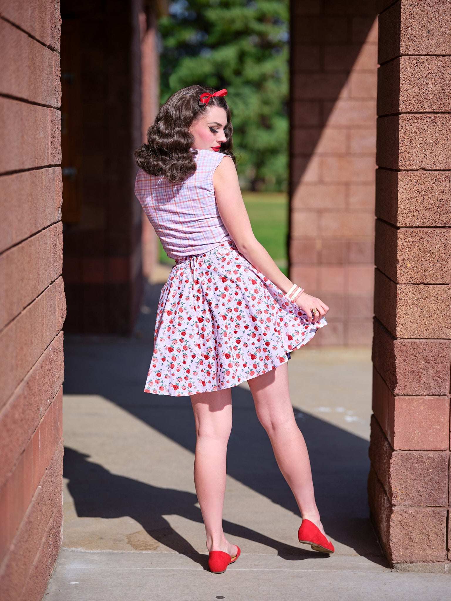 a full length of the back view of a model wearing our plaid bow top
