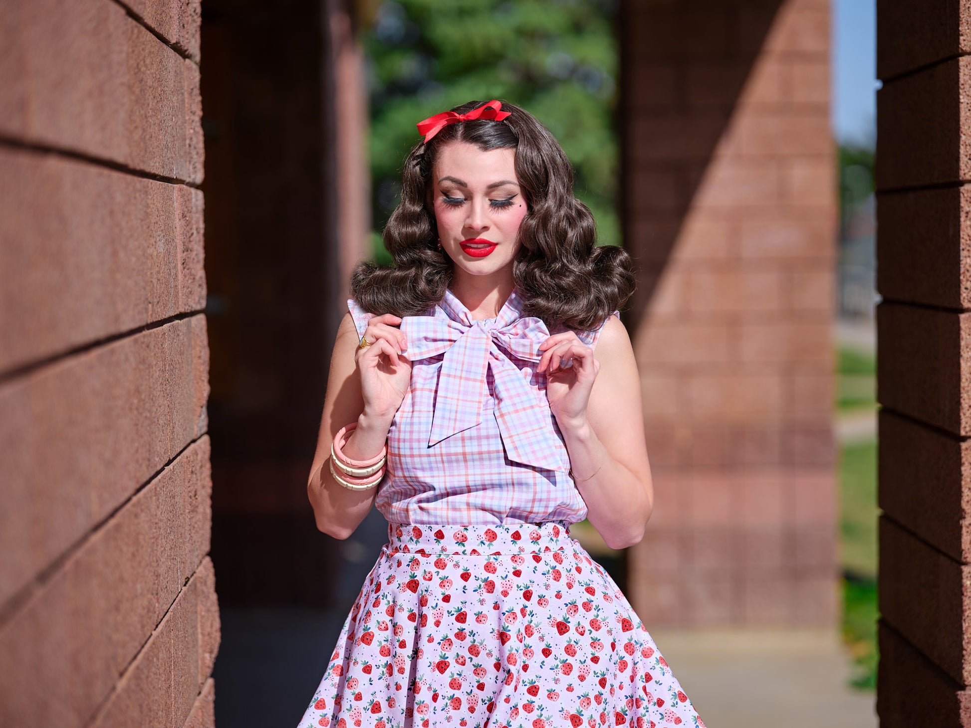 a close up of a model wearing our plaid bow top