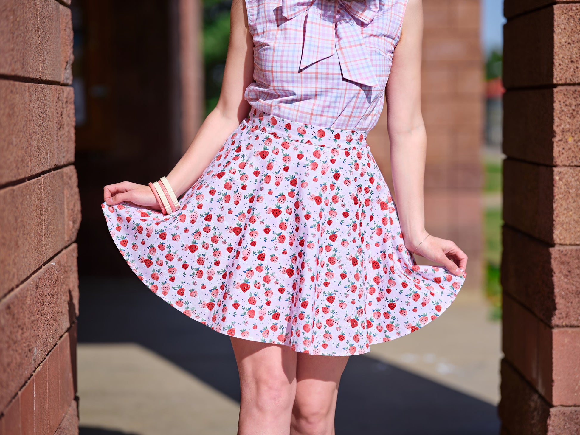 a close up of model standing outside wearing strawberry skater skirt