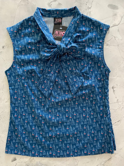 a flat lay of our sleeveless bow tie blouse with sailboat fabric